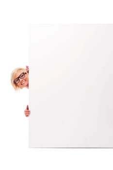 Happy young woman peeking from behind whiteboard