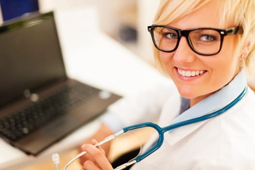 Portrait of beautiful blonde female doctor wearing glasses
