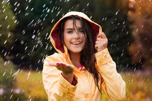Pretty young woman in yellow raincoat