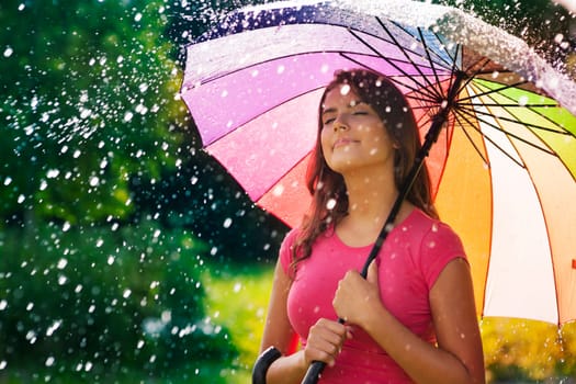 Young woman breathing fresh air during the spring rain