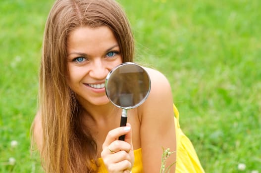 Beauty woman looking through magnifying glass