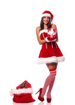 Beautiful woman wearing santa claus clothes holding christmas gift