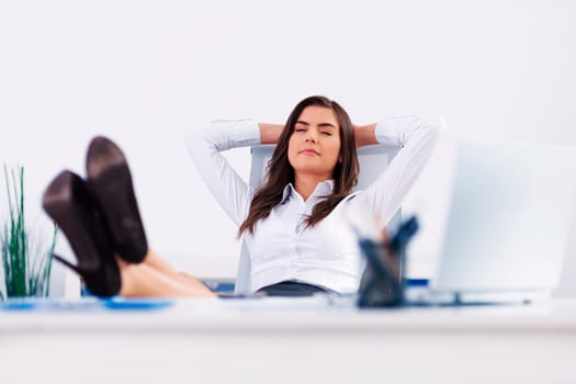 Young businesswoman relaxing in office