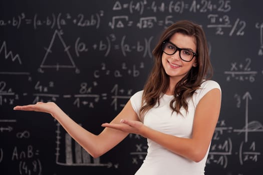 Woman wearing in glasses showing mathematical formulas