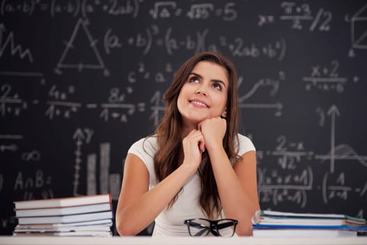 Happy woman sitting in classroom and looking up