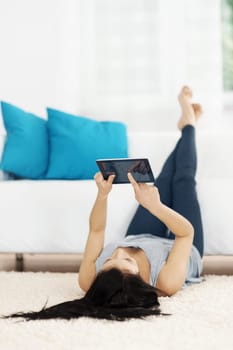 Young woman using tablet on the floor