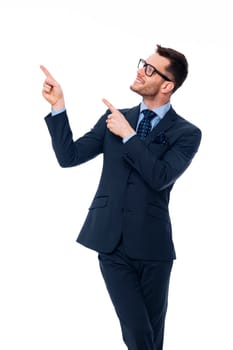 Smiling young businessman pointing at copy space