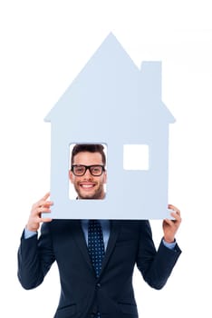 Smiling businessman holding house sign