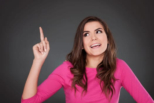 Cheerful woman pointing at copyspace