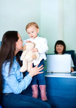 Mother entertaining her daughter at doctors office
