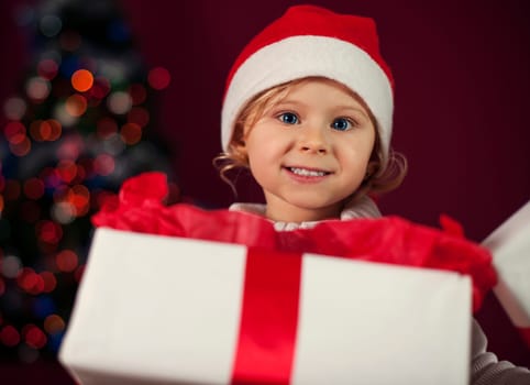 Santa little girl opening christmas present
