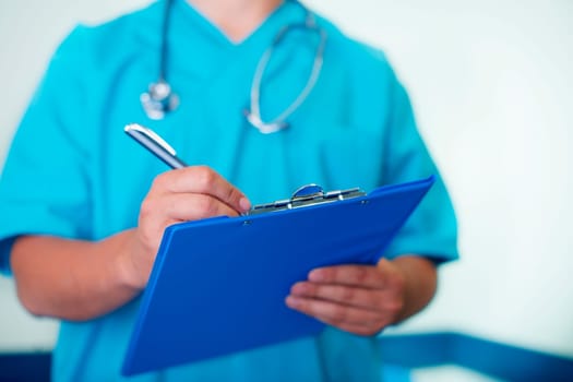 Doctor writing down on medical chart