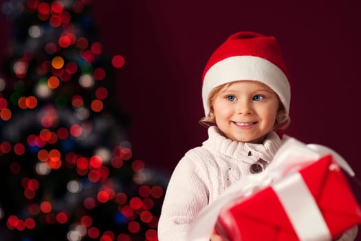 Little girl holding red gift box