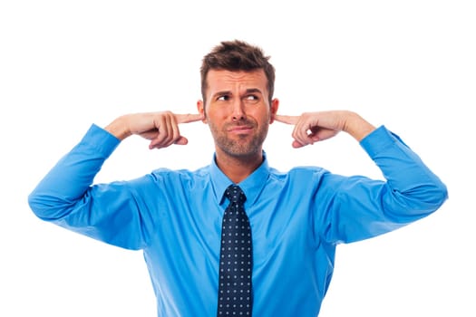 Disgust business man with fingers in ears