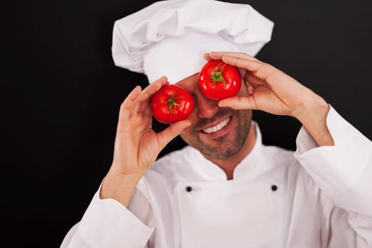 Happy chef covering his eyes of tomatoes