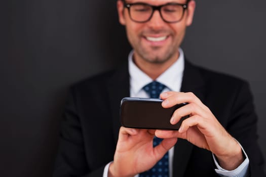 Businessman texting on smart phone