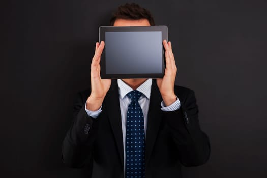 Businessman holding digital tablet front of his face