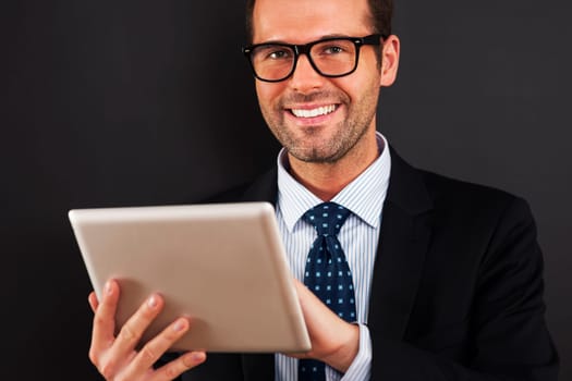 Businessman wearing glasses using digital tablet