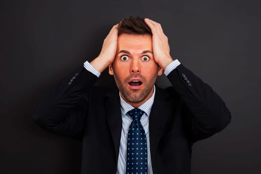 Businessman holding his head and screaming