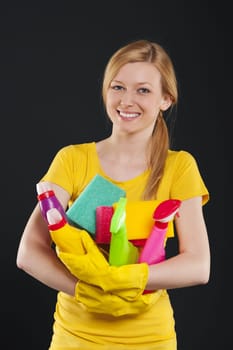 Happy blonde woman holding cleaning equipment