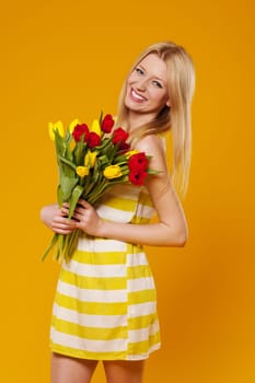 Young woman wearing in sundress with bouquet of tulips