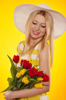 Spring portrait of a beautiful young woman with tulips