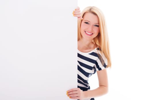 Cheerful blonde woman pointing at blank whiteboard