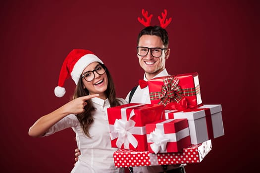 Smiling nerd couple showing christmas gift