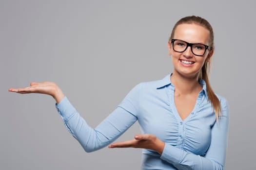 Young smiling businesswoman showing at copy space