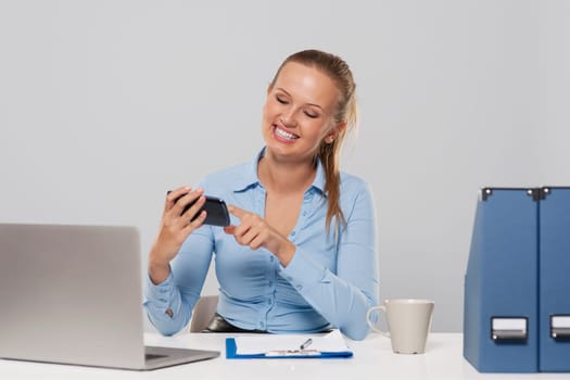 Happy woman using mobile phone during the office work
