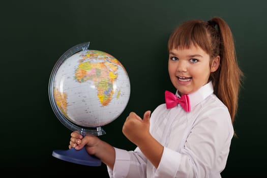 Schoolgirl with globe showing ok sign