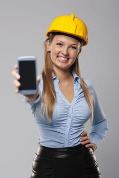 Smiling architect woman showing screen of smart phone
