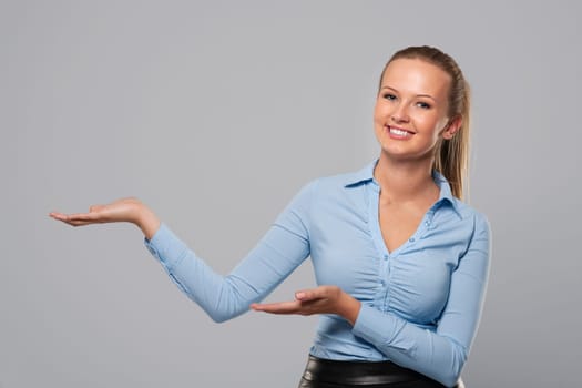 Smiling woman in formal wear showing at copy space