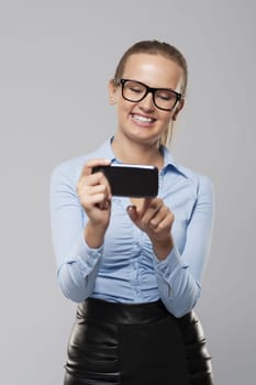 Happy young business woman text messaging on smart phone