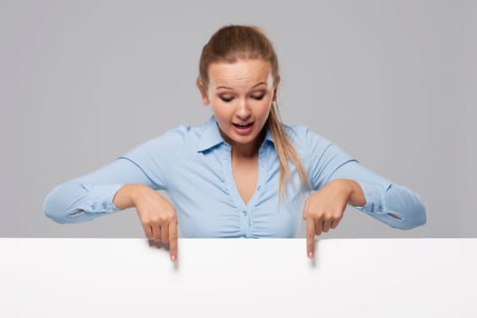 Smiling and surprised beautiful businesswoman pointing at whiteboard