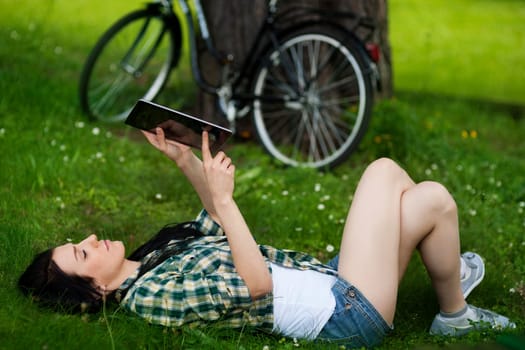 Beautiful young woman using digital tablet outdoors