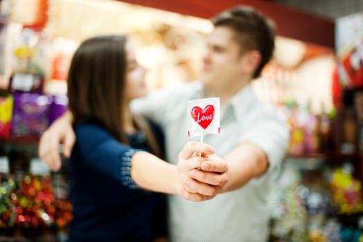 Couple holding lollipop in their hands