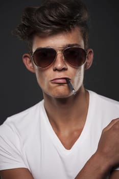 Stylish young man with cigarette between lips