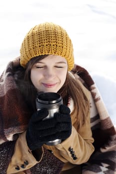 Young woman drinking hot drink outdoors