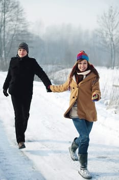 Young couple running through the park