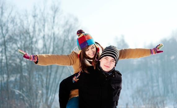 Young man giving his girlfriend a piggyback ride