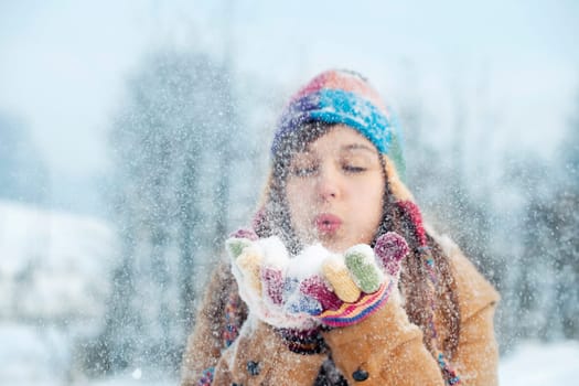 Young woman blowing snow to away