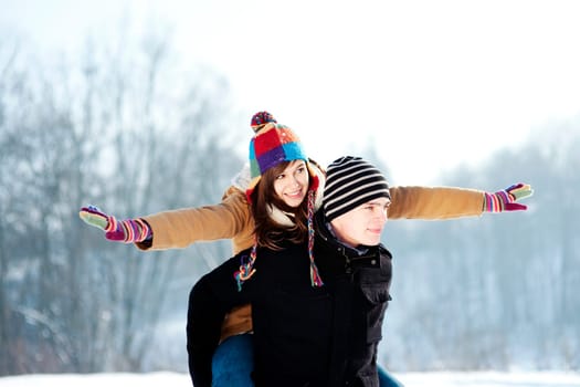 Young man giving his girlfriend a piggyback ride
