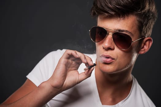 Stylish young man smoking cigarette