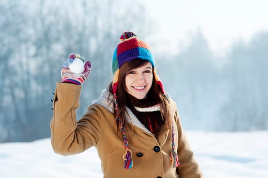 Young woman throwing snowball