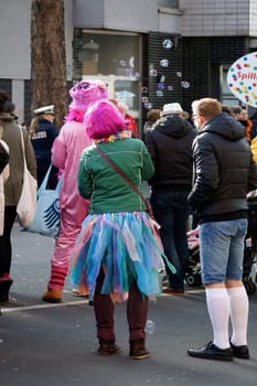 Cologne,Germany – March 02,2014: A colourfully dressed woman blows soap bubbles into the air during the carnival procession in Cologne on March 2,2014.