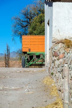 Vertical view of an orange and green wagon un rural Bolivia near Potosi