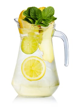 Full jug of fresh birch juice with lemon, ginger and mint leaves isolated