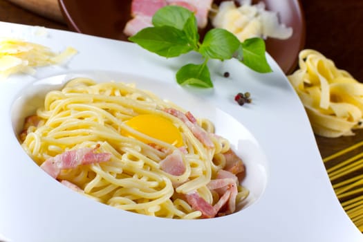 Italian pasta with sauce, parmesan cheese and yolk, served on a white plate