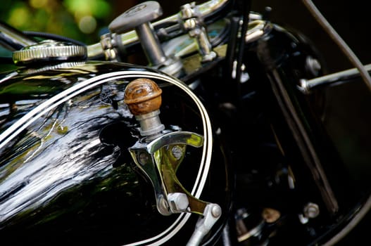 Detail of motorcycle gas tank shifter on vintage black motorcycle.